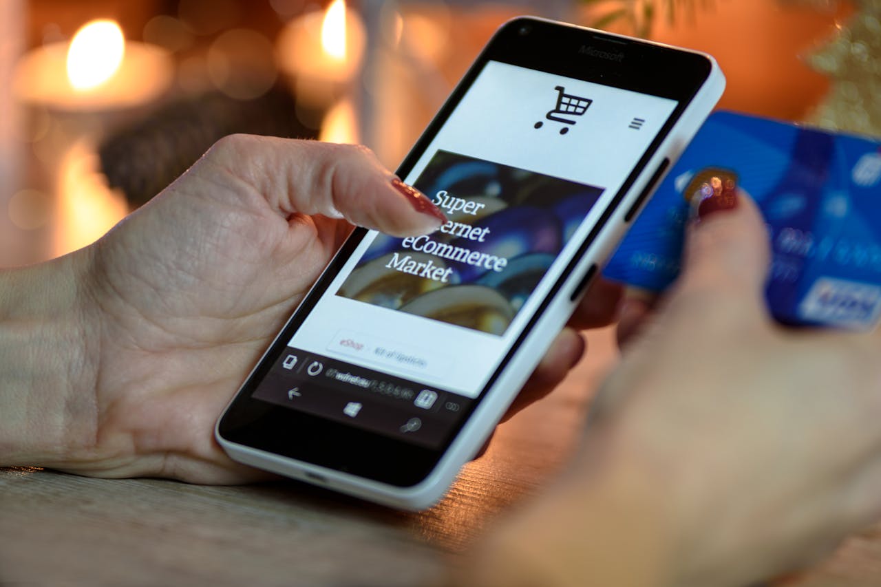 hero-img Woman using smartphone for online shopping with credit card in hand, festive background lighting.